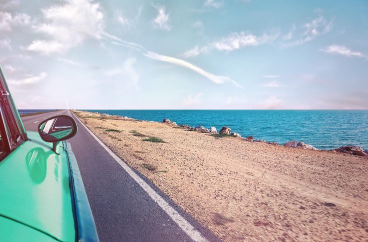 green-car-near-seashore-with-blue-ocean-1118448